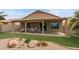 Charming covered patio with dining set, artificial turf, and desert landscaping, creating a private backyard oasis at 16205 W Mountain Pass Dr, Surprise, AZ 85374