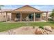 Covered patio with stylish seating, perfect for outdoor dining, surrounded by artificial turf and desert landscaping at 16205 W Mountain Pass Dr, Surprise, AZ 85374