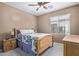 Cozy bedroom features a wooden bed frame, ceiling fan, and carpeted floors at 16987 W Hammond St, Goodyear, AZ 85338