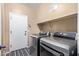 Well-equipped laundry room with modern washer and dryer units and functional shelving at 16987 W Hammond St, Goodyear, AZ 85338