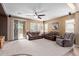 Spacious living room with neutral carpet, a ceiling fan, and large windows for natural light at 16987 W Hammond St, Goodyear, AZ 85338