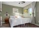 Bright bedroom with white comforter, neutral tones, and large window providing natural light at 1702 W Glenrosa Ave, Phoenix, AZ 85015