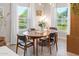 Bright dining area featuring a wooden table, black chairs, and large windows with sheer white curtains at 1702 W Glenrosa Ave, Phoenix, AZ 85015