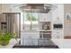 Bright kitchen featuring a glass range hood, stainless steel appliances, and white cabinetry at 1702 W Glenrosa Ave, Phoenix, AZ 85015