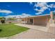 Exterior view of the backyard featuring a covered patio, gravel, grass, and mature trees at 1713 W Palomino Dr, Chandler, AZ 85224