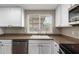 Close-up of kitchen sink, white cabinets, and countertops with window view at 1713 W Palomino Dr, Chandler, AZ 85224