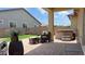 Relaxing backyard featuring a hot tub, covered patio, and wicker furniture on a brick patio and artificial grass at 17211 W Whispering Wind Rd, Surprise, AZ 85387