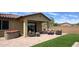 Relaxing backyard with artificial turf, paved patio, a hot tub, and comfortable wicker seating at 17211 W Whispering Wind Rd, Surprise, AZ 85387