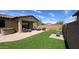 Inviting backyard featuring artificial turf, covered patio with wicker furniture, pavers and a hot tub at 17211 W Whispering Wind Rd, Surprise, AZ 85387