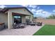 Backyard featuring a covered patio, a brick patio, wicker seating, artificial grass, and a hot tub at 17211 W Whispering Wind Rd, Surprise, AZ 85387