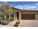 Inviting single-story home featuring a well-manicured front yard and a charming covered entrance at 17211 W Whispering Wind Rd, Surprise, AZ 85387