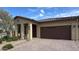 Welcoming home with a tile roof, landscaped front yard, and attached two-car garage at 17211 W Whispering Wind Rd, Surprise, AZ 85387