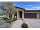 Inviting home with a landscaped front yard, brick driveway, and charming covered entrance at 17211 W Whispering Wind Rd, Surprise, AZ 85387