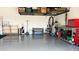Tidy garage with storage racks, epoxy flooring, and space for parking and projects at 17211 W Whispering Wind Rd, Surprise, AZ 85387