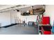 Well-organized garage with overhead storage racks, epoxy flooring, and a side door at 17211 W Whispering Wind Rd, Surprise, AZ 85387