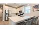 Modern kitchen with stainless steel appliances, white cabinets, large sink island with seating, and tiled flooring at 17211 W Whispering Wind Rd, Surprise, AZ 85387