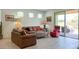 Cozy living room featuring tile floors, comfortable seating, and lots of natural light at 17211 W Whispering Wind Rd, Surprise, AZ 85387