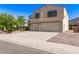 Two-story home featuring paired garages, desert landscaping, and a concrete driveway for multiple cars at 1737 E Primera Dr, Casa Grande, AZ 85122