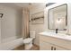 Bathroom featuring a shower-tub combo, white vanity, modern mirror, and neutral decor at 1747 W Echo Ln, Phoenix, AZ 85021