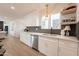 Updated kitchen with stainless steel appliances, white cabinets, and adjacent dining area at 1747 W Echo Ln, Phoenix, AZ 85021