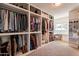 Spacious walk-in closet with custom built-ins, vanity, and ample storage for clothing and accessories at 1747 W Echo Ln, Phoenix, AZ 85021