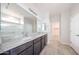 Bathroom showcasing double sinks with granite countertop, tile flooring, and a glass-enclosed shower at 17977 W Camino De Oro Riv, Surprise, AZ 85387