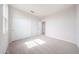 Bright bedroom with neutral carpet, white walls, closet, and an open door to the hallway at 17977 W Camino De Oro Riv, Surprise, AZ 85387