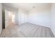 Bright bedroom with neutral carpet, white walls, closet, and an open door to another room at 17977 W Camino De Oro Riv, Surprise, AZ 85387