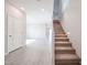 Open floor plan featuring stairway with carpet runner, neutral tile flooring, and access to the 2nd floor at 17977 W Camino De Oro Riv, Surprise, AZ 85387