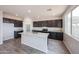 Modern kitchen featuring a spacious island, granite countertops, and dark cabinets at 17977 W Camino De Oro Riv, Surprise, AZ 85387