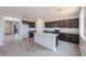 Spacious open-concept kitchen with gray-wood-look tile and modern finishes at 17977 W Camino De Oro Riv, Surprise, AZ 85387