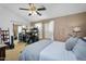 This main bedroom with carpet flooring features a ceiling fan, a desk and workspace, and a sliding glass door closet at 18811 N 34Th Ave # 6, Phoenix, AZ 85027