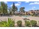 Community pool and lounge area with well-manicured greenery, chairs, and community buildings in the background at 18811 N 34Th Ave # 6, Phoenix, AZ 85027