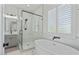 Bathroom featuring a modern shower, freestanding tub, and double shutters at 18826 E Augusta Ave, Queen Creek, AZ 85142