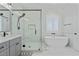 Bathroom featuring a modern shower, freestanding tub, white tile and black hardware at 18826 E Augusta Ave, Queen Creek, AZ 85142