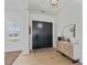 Bright foyer with striking black double doors, wood flooring, stylish console table, and modern decor at 18826 E Augusta Ave, Queen Creek, AZ 85142