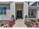 Elegant front entrance featuring double doors, stone facade, colorful flowers, and manicured landscaping at 18826 E Augusta Ave, Queen Creek, AZ 85142
