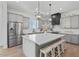 Bright kitchen features an island with seating, stainless appliances, and pendant lighting at 18826 E Augusta Ave, Queen Creek, AZ 85142