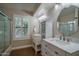 Charming bathroom with a round mirror, white cabinetry, quartz counters, and a window with shuttered blinds at 19115 N 71St Dr, Glendale, AZ 85308