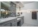 Beautiful bathroom with a double vanity sink, modern tile and fixtures, and a glass shower with an arched window at 19115 N 71St Dr, Glendale, AZ 85308
