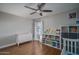 Bright bedroom with a ceiling fan, light walls, wood floors, and a white bookshelf and dresser at 19115 N 71St Dr, Glendale, AZ 85308