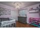 Charming Bedroom with pink walls, a crystal chandelier, wood floors, and a gray crib and changing table at 19115 N 71St Dr, Glendale, AZ 85308