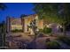 Charming home exterior with desert landscaping, stucco facade, and covered entrance at dusk at 19115 N 71St Dr, Glendale, AZ 85308
