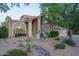 Attractive landscaping frames this beautiful home, featuring mature trees, desert plants and a charming facade at 19115 N 71St Dr, Glendale, AZ 85308