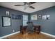 Comfortable home office with a wooden desk, gray walls, wood floors, and a ceiling fan at 19115 N 71St Dr, Glendale, AZ 85308