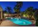 Inviting pool with waterfall feature, lush tropical landscaping, and underwater lighting, perfect for evening swims and relaxation at 19115 N 71St Dr, Glendale, AZ 85308