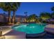 Beautiful backyard pool with spa, waterfall feature, ambient lighting, and lush tropical landscaping, perfect for entertaining at 19115 N 71St Dr, Glendale, AZ 85308