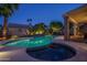 Backyard pool with jacuzzi, waterfall, tropical landscaping, outdoor kitchen, and ambient lighting for memorable evenings at 19115 N 71St Dr, Glendale, AZ 85308