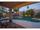 Inviting pool with palm trees, lush landscaping, and a covered patio with comfortable seating at 19115 N 71St Dr, Glendale, AZ 85308