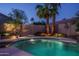 Backyard pool area with diving board, rock features, lush landscaping, and privacy fence, offering a private and fun outdoor space at 19115 N 71St Dr, Glendale, AZ 85308